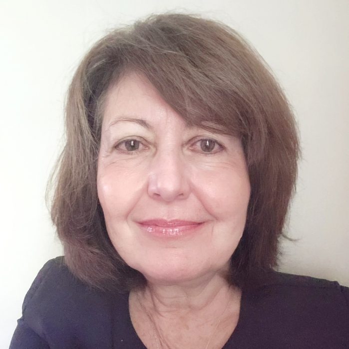 Photo of a middle-aged woman with short brown hair and a soft smile